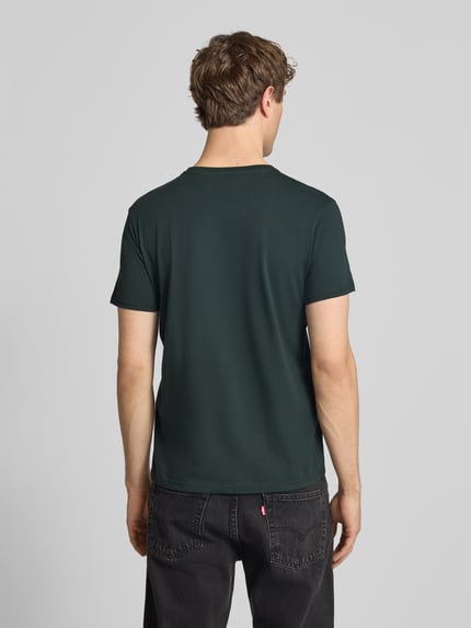 Männermodel trägt T-Shirt mit Label-Detail Modell 'BASIC' von Alpha Industries in Dunkelgrün, Reine Baumwolle, Gerader-Schnitt, Rückenansicht, Rückenlänge bei Größe M: 69 cm.