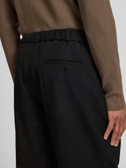 Männermodel trägt Regular Fit Hose mit Leinen-Anteil von Emporio Armani in Schwarz, glatte Textur, Detailaufnahme Rückansicht, Lyocell-Mix.