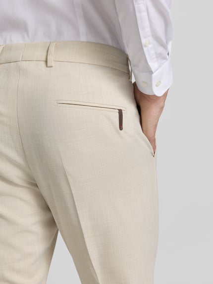 Männermodel trägt Hose mit Bügelfalten Modell 'Beppe' von CINQUE in Beige, glatte Textur, Slim Fit, Nahaufnahme Rückansicht, Material-Mix mit Viskose-Anteil