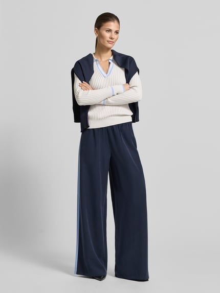 Vrouwenmodel draagt Geripptes Longsleeve mit V-Ausschnitt - curated by Tinvcb van SIC, gebroken wit met blauwe details, slim fit, resortkraag, v-hals, geribde boorden, zuivere katoen, lange mouwen, elegant gecombineerd met marineblauwe broek, Ganzkörperansicht von vorne.