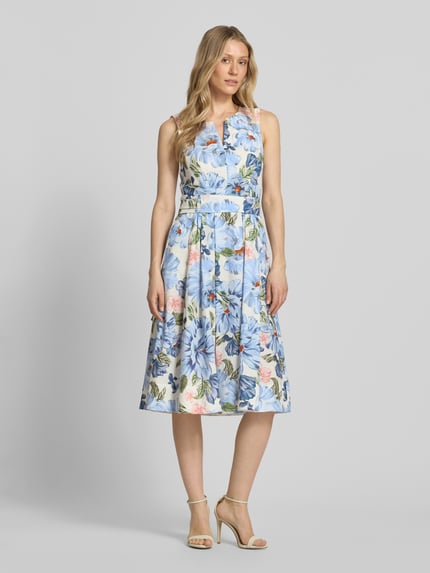 Vrouwenmodel draagt midi-jurk met bloemen all-over print van Oui, puur katoen, getailleerd, plooienlook, mouwloos design, ruglengte maat 36: 111 cm, borstwijdte maat 36: 43 cm. Ganzkörperansicht von voren.
