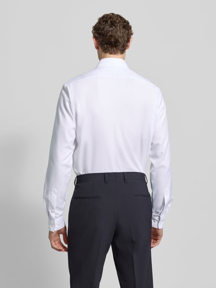 Männermodel trägt weißes Modern Fit Businesshemd mit extra langem Arm von OLYMP aus reiner Baumwolle, Rückenansicht Ganzkörperansicht.