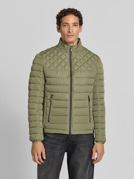 Männermodel trägt Steppjacke mit Stehkragen und Reißverschlusstaschen von Christian Berg Men, olivgrün, Regular Fit, Ganzkörperansicht von vorne.