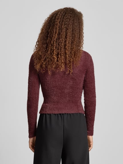 Frauenmodel trägt Slim Fit Strickpullover Modell 'VIOLA' von Only in unifarbener Optik, Rundhals, Langarm, Rückenansicht, Damen Strickpullover.