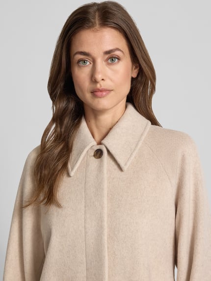 Frauenmodel trägt Jacke aus Woll-Mix mit Kentkragen Modell 'Tary' von mbyM in Beige, verdeckte Knopfleiste, Nahaufnahme Oberkörper.