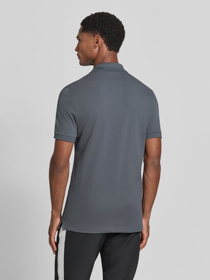 Männermodel trägt Slim Fit Poloshirt aus reiner Baumwolle von Lacoste in Grau, Rückansicht, Herren Poloshirt von Lacoste, Ganzkörperansicht Rückansicht.