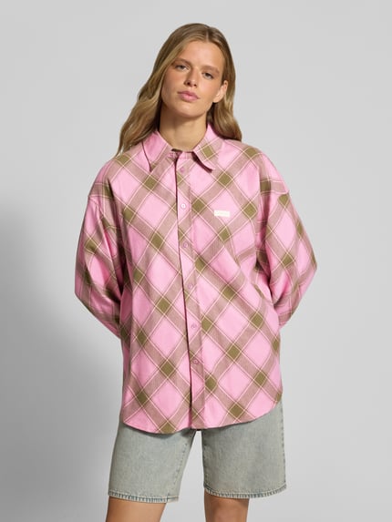 Kobiece model nosi bluzkę z bawełny o kroju relaxed fit Relaxed Fit Bluse mit Label-Detail Modell 'Vivian' od OH APRIL w wzór na całej powierzchni, kołnierzyk koszulowy, detal z logo, długość tyłu w rozmiarze S: 80 cm, długość rękawów w rozmiarze S: 58 cm, jasnoróżowe i beżowe odcienie, miękka tekstura, całościowy widok z przodu.
