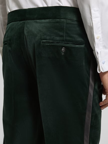 Männermodel trägt Slim Fit Anzug aus Samt von Lindbergh, dunkles Grün, samtige Textur, Detailaufnahme Rückansicht, KI-modifiziertes Bild.