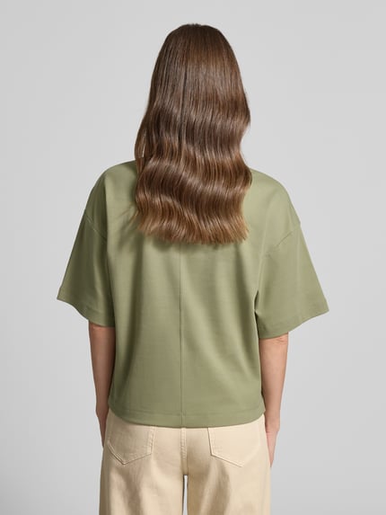 Frauenmodel trägt Oversized T-Shirt aus reiner Baumwolle von s.Oliver RED LABEL, Optik: Unifarben, oversized, Logo-Applikation, Rundhals, Ärmelform: Kurzarm, Materialverarbeitung: Jersey; Ganzkörperansicht Rückansicht.