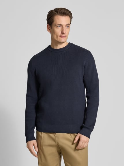 Männermodel trägt Relaxed Fit Strickpullover mit Rundhalsausschnitt von Lindbergh in Dunkelblau, Ripp-Optik, Ganzkörperansicht von vorne.
