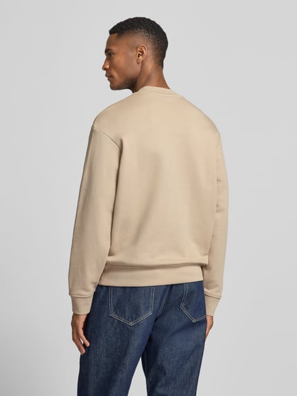 Mannelijk model draagt 'Sweatshirt met logo-print en ronde hals' van ARMANI EXCHANGE in beige, loose fit, zuiver katoen, rugaanzicht.