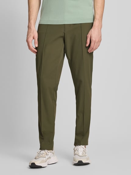 Männermodel trägt Regular Fit Hose mit Bügelfalten Modell 'PS SPIRIT70' von BOSS Green, Optik: Unifarben, Ganzkörperansicht von vorne. Passform: Regular Fit, Applikation: Label-Schriftzug, Details: Gürtelschlaufen, Verschluss: Knopf und verdeckter Reißverschluss, Materialverarbeitung: Stretch.
