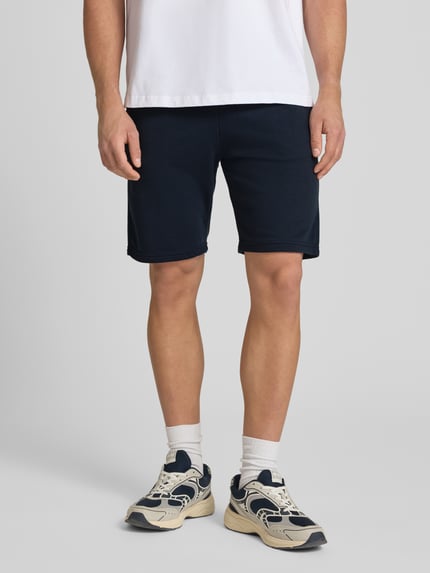 Männermodel trägt Sweatshorts mit elastischem Bund Modell 'KARLOS' von Blend, dunkelblau, Baumwoll-Mix, Regular-Fit, Nahaufnahme Oberkörper. Bundweite bei Größe M: 42 cm, Innenbeinlänge bei Größe M: 21 cm, Tunnelzug.