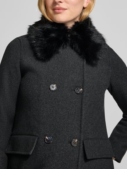 Frauenmodel trägt Wollmantel mit Webpelzkragen von VERO MODA in Dunkelgrau, Struktur, Zierknöpfe, Pattentaschen, Nahaufnahme Oberkörper.