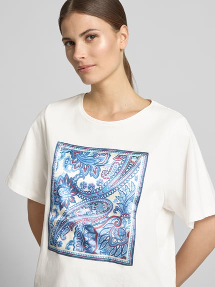Frauenmodel trägt T-Shirt mit Rundhalsausschnitt von Oui aus reiner Baumwolle, weiß mit blau-rotem Motiv, Boxy Fit, Nahaufnahme Oberkörper