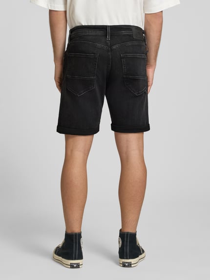 Männermodel trägt Jeansshorts mit Umschlag Modell 'RICK' von Jack & Jones in Schwarz, Baumwoll-Mix, Regular Fit, Ganzkörperansicht Rückansicht.