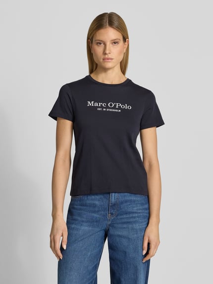 Frauenmodel trägt Regular Fit T-Shirt aus reiner Baumwolle von Marc O'Polo in Unifarbe Dunkelblau, Rundhals, Label Print, Ganzkörperansicht von vorne.