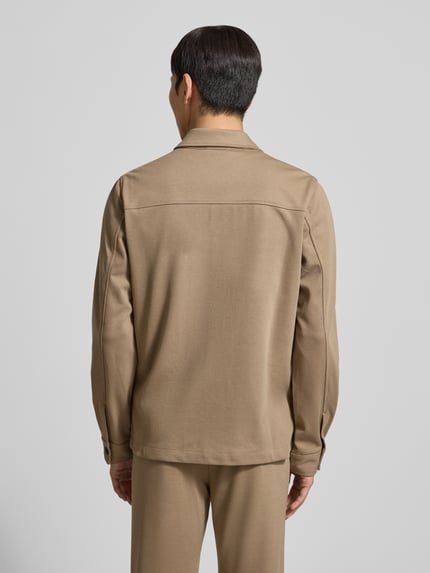 Männermodel trägt Hemdjacke mit Knopfleiste von Lindbergh in Beige, Regular Fit, glatte Textur, Ganzkörperansicht Rückansicht.