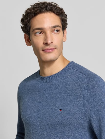 Männermodel trägt Regular Fit Pullover aus Lammwoll-Mix von Tommy Hilfiger in blau, Strukturstrick mit Logo-Detail, Nahaufnahme Oberkörper