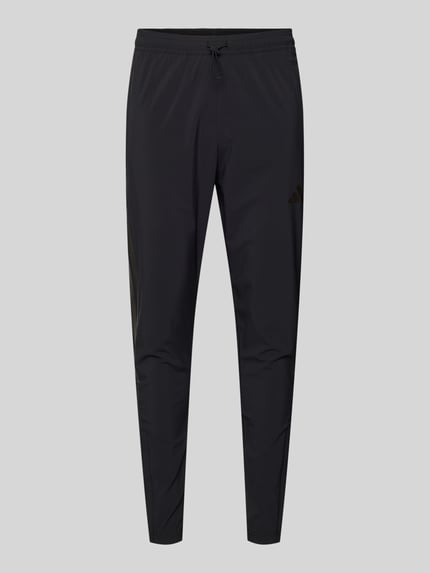 Produktfoto, spodnie dresowe z elastycznym paskiem Sweatpants mit elastischem Bund von adidas Sportswear, mieszanka materiałów z dodatkiem streczu, luźny krój, tunel, wpuszczane kieszenie, długość wewnętrzna nogawki 71 cm, kolor czarny, gładka tekstura