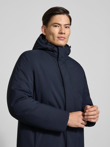 Männermodel trägt Parka mit Kapuze Modell 'Crauler' von BOSS in Dunkelblau, unifarben, Longline, Nahaufnahme Oberkörper, Herren Parka.