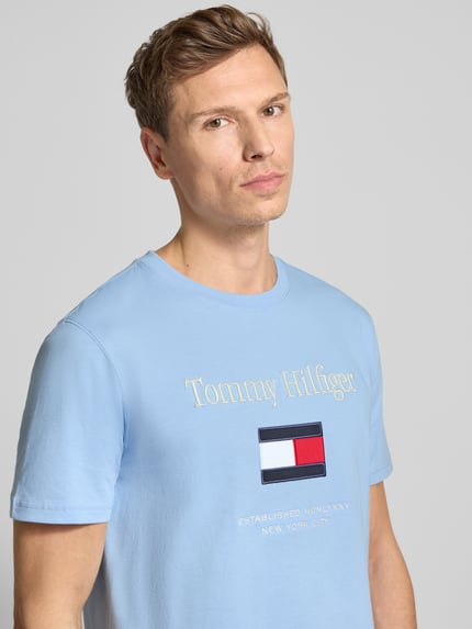 Männermodel trägt Regular Fit T-Shirt aus reiner Baumwolle von Tommy Hilfiger in Optik: unifarben mit Label-Schriftzug, Jersey, Nahaufnahme Oberkörper.