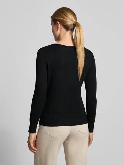 Frauenmodel trägt Regular Fit Strickpullover aus Viskose-Mix mit U-Boot-Ausschnitt von Christian Berg Woman in Schwarz, gerippte Abschlüsse, langärmeliges Design, Damenpullover mit überschnittenen Schultern, Ganzkörperansicht Rückansicht.