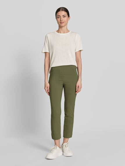 Modelka nosi Caprihose aus Viskose-Mix Modell 'Igor3' von Stehmann, zielony kolor, krój slim fit, elastyczny pas, Szerokość w rozmiarze 36: 38 cm, długość nogawki od wewnątrz w rozmiarze 36: 69 cm, Ganzkörperansicht von vorne