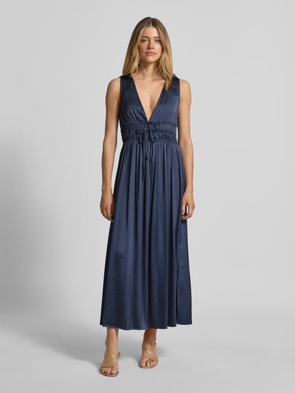 Frauenmodel trägt Maxikleid mit tiefem V-Ausschnitt Modell 'Marja' von mbyM, dunkelblauer Material-Mix mit Viskose-Anteil, taillierter Schnitt, Schnürung, Ganzkörperansicht von vorne.