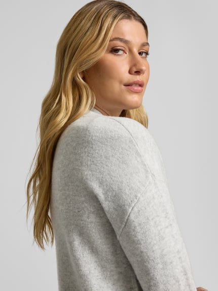 Frauenmodel trägt Strickjacke in offener Passform von Christian Berg Woman, helle Farbe, reine Baumwolle, Nahaufnahme Oberkörper, Regular Fit, gerippte Abschlüsse.