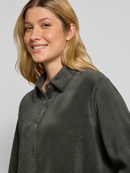 Frauenmodel trägt Regular Fit Bluse aus Cord Modell 'Zortney' von someday in Dunkelgrün, Hemdblusenkragen, Knopfleiste, Nahaufnahme Oberkörper.