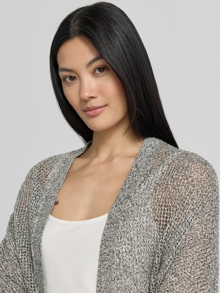 Vrouwenmodel draagt 'Strickjacke in offener Passform mit 3/4-Arm' van comma, puur katoen, structuurpatroon, lichtgrijs, nahaufnahme bovenlichaam.