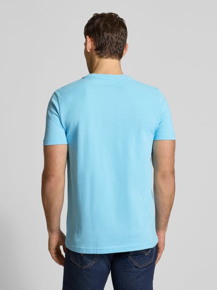 Mężczyzna nosi T-Shirt aus Baumwolle mit Rundhalsausschnitt od Christian Berg Men w kolorze jasnoniebieskim, krój regular fit, materiał bawełniany, detal z logo, długość tyłu w rozmiarze M: 71 cm, całkowity widok z tyłu.