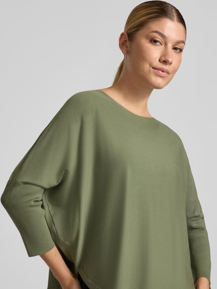 Frauenmodel trägt Strickpullover aus Viskose-Mix Modell 'Tiraja' von someday, Olivgrün, Relaxed Fit mit 3/4-Arm, Nahaufnahme Oberkörper.