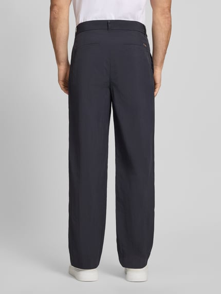 Męski model nosi Hose mit Gesäßtaschen und Label-Detail von ARMANI EXCHANGE, krój regular fit, granat, tekstura gładka, tylna perspektywa całej sylwetki