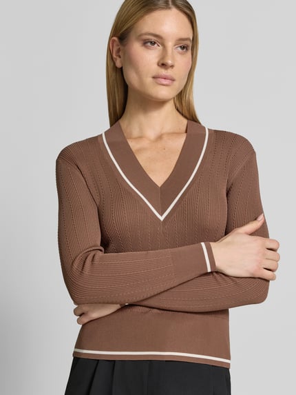 Frauenmodel trägt Slim Fit Pullover aus Viskose-Mix in Strick-Optik von ARMANI EXCHANGE, V-Ausschnitt, breite elastische Abschlüsse, Nahaufnahme Oberkörper.