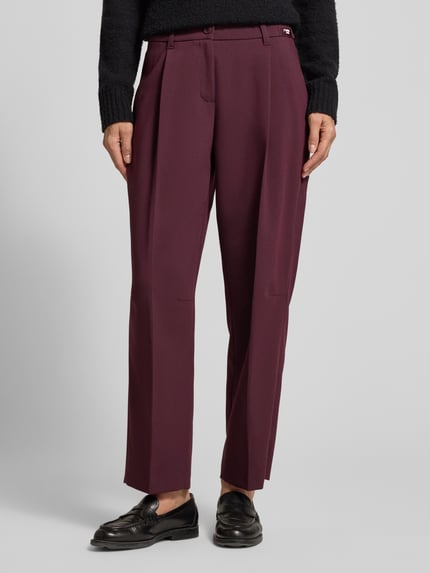 Kobieta nosi Cropped Barrel Leg Hose mit Bundfalten Modell 'Ortensia' od CAMBIO, kolor jednolity, tkanina o strukturze, widok całej sylwetki z przodu.