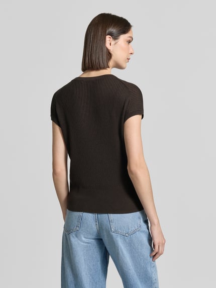 Vrouwenmodel draagt T-shirt uit mix van lyocell en linnen model 'Tianna' van Someday in riblook, regular fit, ruglengte maat 36: 50 cm. Ganzkörperansicht Rückansicht.
