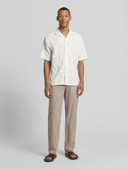 Männermodel trägt Hose aus Leinen-Baumwoll-Mix mit elastischem Bund von Lindbergh, Regular-Fit, Eingrifftaschen, Ganzkörperansicht von vorne. Bundweite bei Größe M: 40 cm, Innenbeinlänge bei Größe M: 79 cm. Helle Naturtöne und leicht strukturierte Stoffoptik.