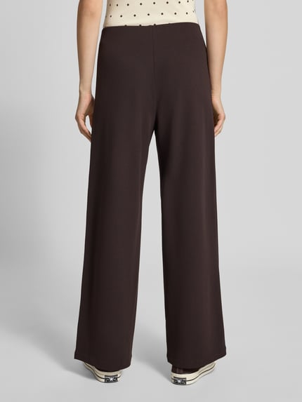 Frauenmodel trägt Weite Hose aus reiner Viskose Modell 'BREMEN' von ONLY in Dunkelbraun, glatte Textur, Damen Weite Hose von ONLY, Ganzkörperansicht Rückansicht.
