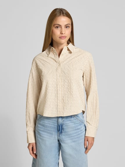 Frauenmodel trägt Boxy Fit Hemdbluse Modell 'IRUYA' von Mango im Allover-Karomuster, Knopfleiste, Material-Mix, Nahaufnahme Oberkörper.