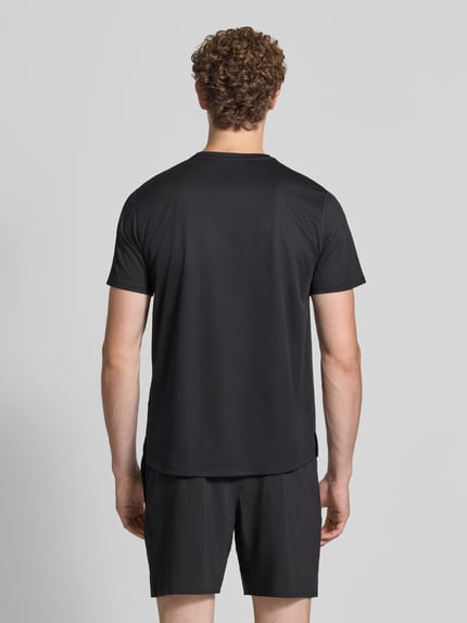 Männermodel trägt schwarzes T-Shirt mit Logo-Print Modell 'CORE' von ASICS TIGER, glatte Struktur, gerader Schnitt, Ganzkörperansicht Rückansicht.