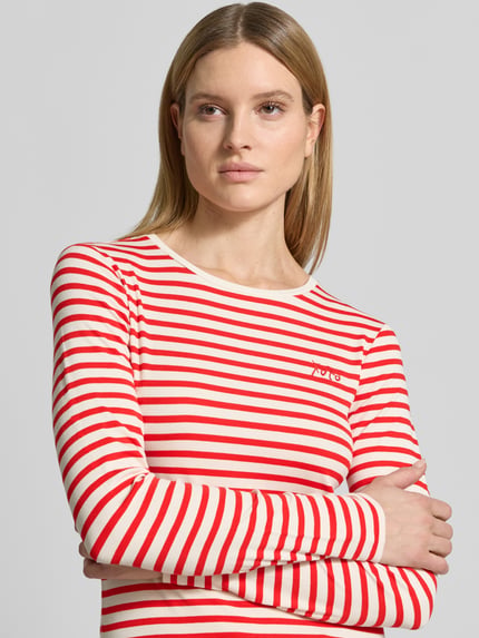 Frauenmodel trägt Longsleeve mit Rundhalsausschnitt und Statement-Stitching von Comma, rot-weiß gestreift, Viskose-Mix mit Stretch-Anteil, Körpernaher Schnitt, Rundhalsausschnitt, Rückenlänge bei Größe 36: 52 cm, Nahaufnahme Oberkörper.