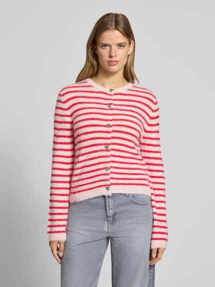 Frauenmodel trägt Strickjacke mit Herzknöpfen von ONLY in Rosa und Rot mit Querstreifen, weiche Textur, Ganzkörperansicht von vorne