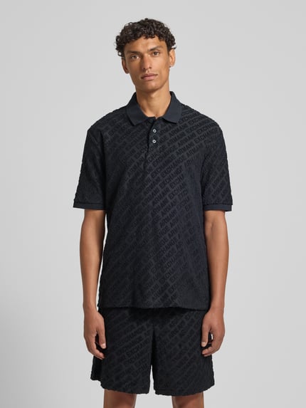 Męski model nosi Slim Fit Poloshirt mit Logo-Muster od ARMANI EXCHANGE, mieszanka bawełny, wzór z logo, krój slim fit, listwa guzikowa, długość tyłu w rozmiarze M 71 cm, widok całej sylwetki z przodu.