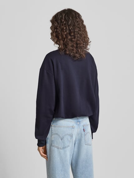 Männermodel trägt Sweatshirt mit Logo-Stitching Modell 'Jana' von LeGer by Lena Gercke, bawełna, luźny krój, elastyczne wykończenia, ujęcie całej sylwetki z tyłu