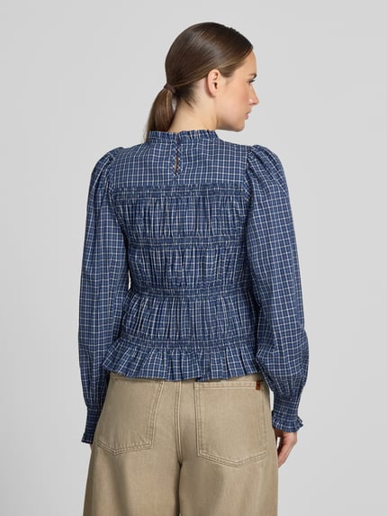 Frauenmodel trägt Bluse mit Smok-Details und Rüschensaum Modell 'Marcia' von Neo Noir aus reiner Baumwolle, karierte Optik, Ganzkörperansicht Rückansicht