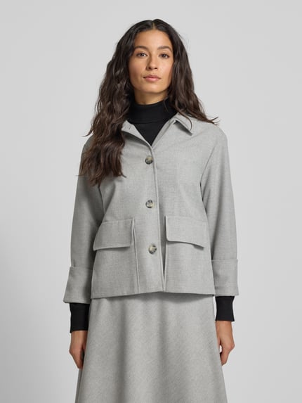 Vrouwenmodel draagt Regular Fit Blazer met klepzakken van More & More, materiaalmix met viscose, platte kraag, knoopsluiting, mouwen met omslag, kleur lichtgrijs, borstwijdte 38 cm, ruglengte 58 cm, mouwlengte 50 cm, voorkant bovenlichaam close-up.