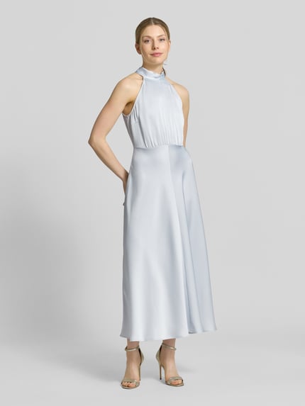 Frauenmodel trägt Midikleid mit Stehkragen Modell 'Rheo' von Samsøe Samsøe in hellem Blau, tailliert, ärmellos, Ganzkörperansicht von vorne.