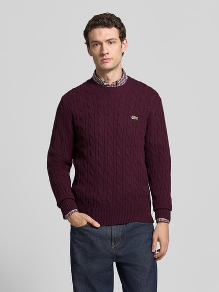Mannenmodel draagt Regular Fit Pullover aus reiner Wolle van Lacoste in donkerpaars met kabelpatroon, Heren pullover, Ganzkörperaanzicht van voren.